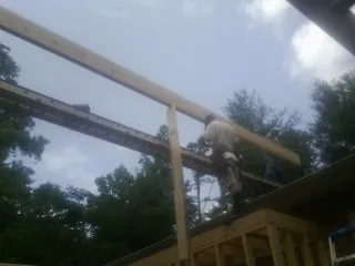 Carpenter setting a ridge beam over a new addition frame — Ice Dam Removal by Roofing Brothers in Marquette